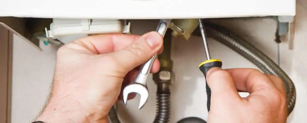 Boiler repair technician tightening pipe fittings and connections in Columbus, OH