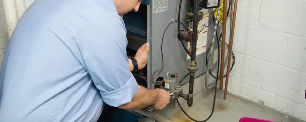 Furnace repair technician inspecting and servicing a home heating system in Columbus, OH