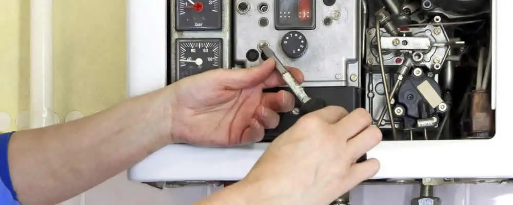 Heating repair technician adjusting boiler controls and components in Columbus, OH