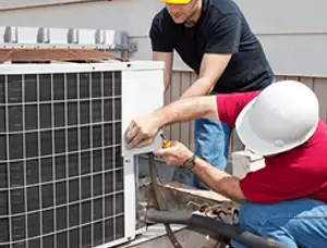 HVAC technicians repairing an outdoor AC unit on a rooftop in Columbus, OH