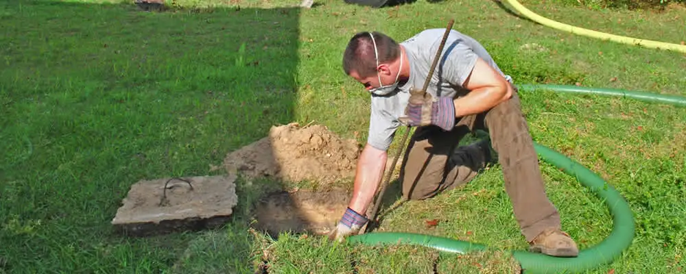 Septic pumping technician servicing a residential septic tank in Columbus, OH