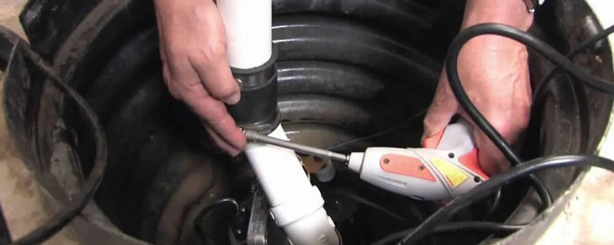 Sump pump installation technician connecting PVC discharge piping in Columbus, OH