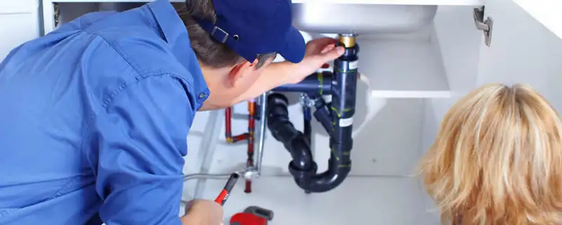 Plumber repairing under-sink drain pipes and fittings in Columbus, OH